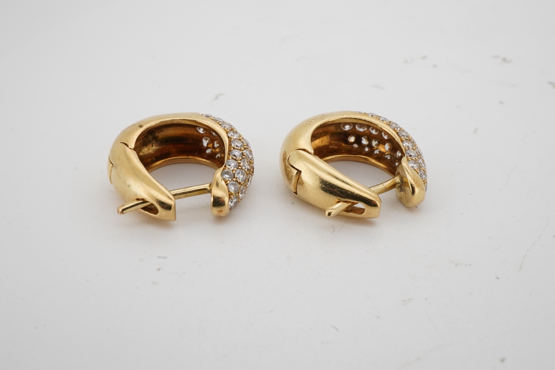 A pair of diamond sleeper earrings, of hinged design, the fronts pavé-set with brilliant-cut diamonds totalling approximately 0.80 carats, length 1.6cm each, post fittings, combined gross weight 6.5 grams